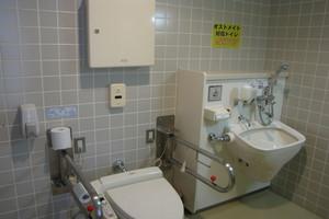 両側に手すりの付いたトイレとその横にオストメイト対応トイレが設置されているトイレ内の写真