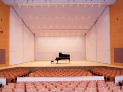 舞台の中央にグラウンドピアノが置かれている文化ホール内部の写真