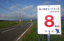 12キロメートル陸上競技ロードコースの 8キロメートル地点の数標識が道路脇に立ててある写真